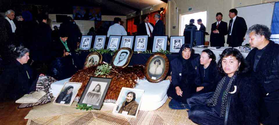 Ngāi Taiwhakaea II, Ngāti Hikakino, and Ngāi Te Rangihouhiri II kuia and women sit beside images of the Ngāti Awa men imprisoned and executed for the 1865 murder of James Fulloon, 6 July 1994. Image supplied by Te Rūnanga o Ngāti Awa