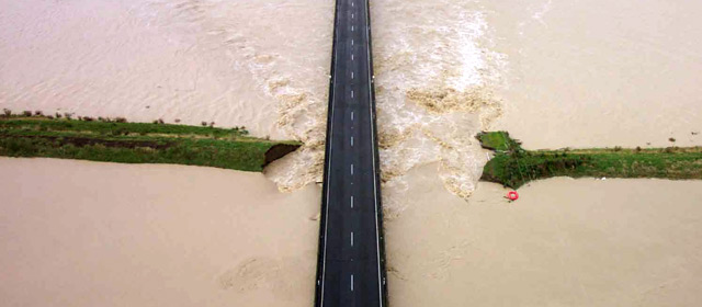 River flooding over banks near road